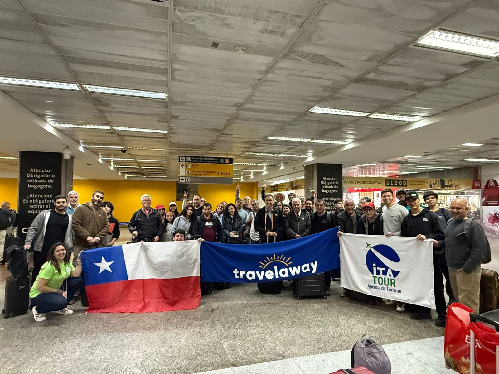 Pasajeros de Tribuna 87 con la bandera de Chile, listos para partir juntos a un gran evento deportivo.